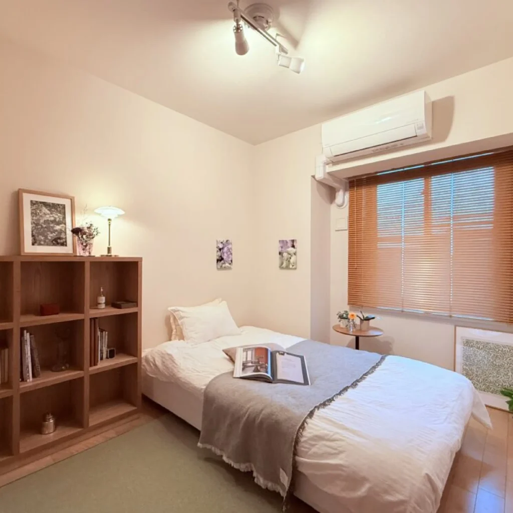 照明とアートの高さのリズムによって奥行きが生まれた寝室