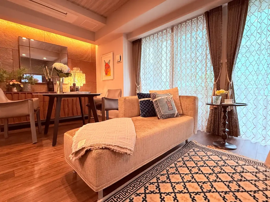 光沢のある張地のソファ、文様の美しいラグが配置された洗練されたワンルーム